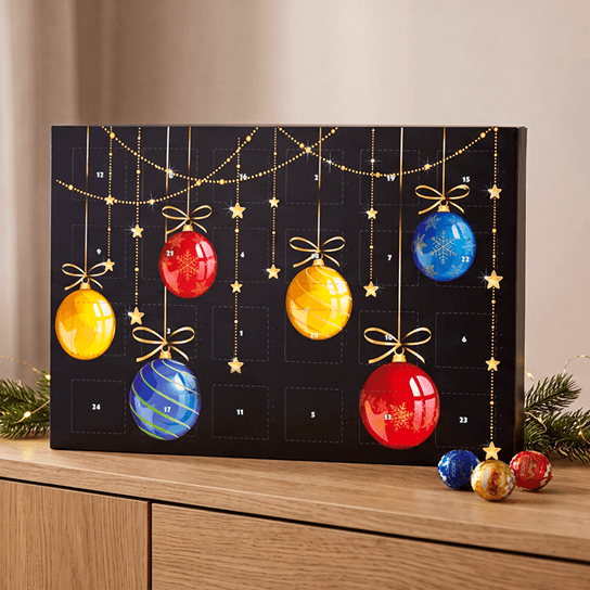 Bedruckter Adventskalender stehend auf einem Sideboard mit Lindt-Lindorkugeln Bedruckter Adventskalender stehend auf einem Sideboard mit Lindt-Lindorkugeln