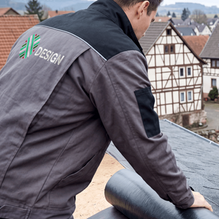 Ein Mann beim Dachdecken in einer auf dem Rücken bestickten Basic-Arbeitsjacke