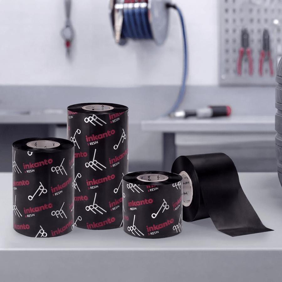 Vier Premium-Thermotransferfolien für Typenschild-Etiketten auf Rolle in verschiedenen Größen auf Tisch in Werkstatt