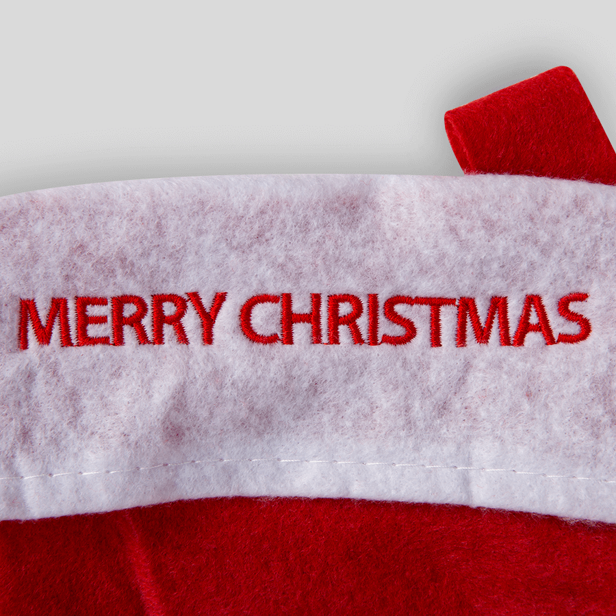 Detailaufnahme einer individuellen Stickerei auf einem rot-weißen Weihnachtsstrumpf